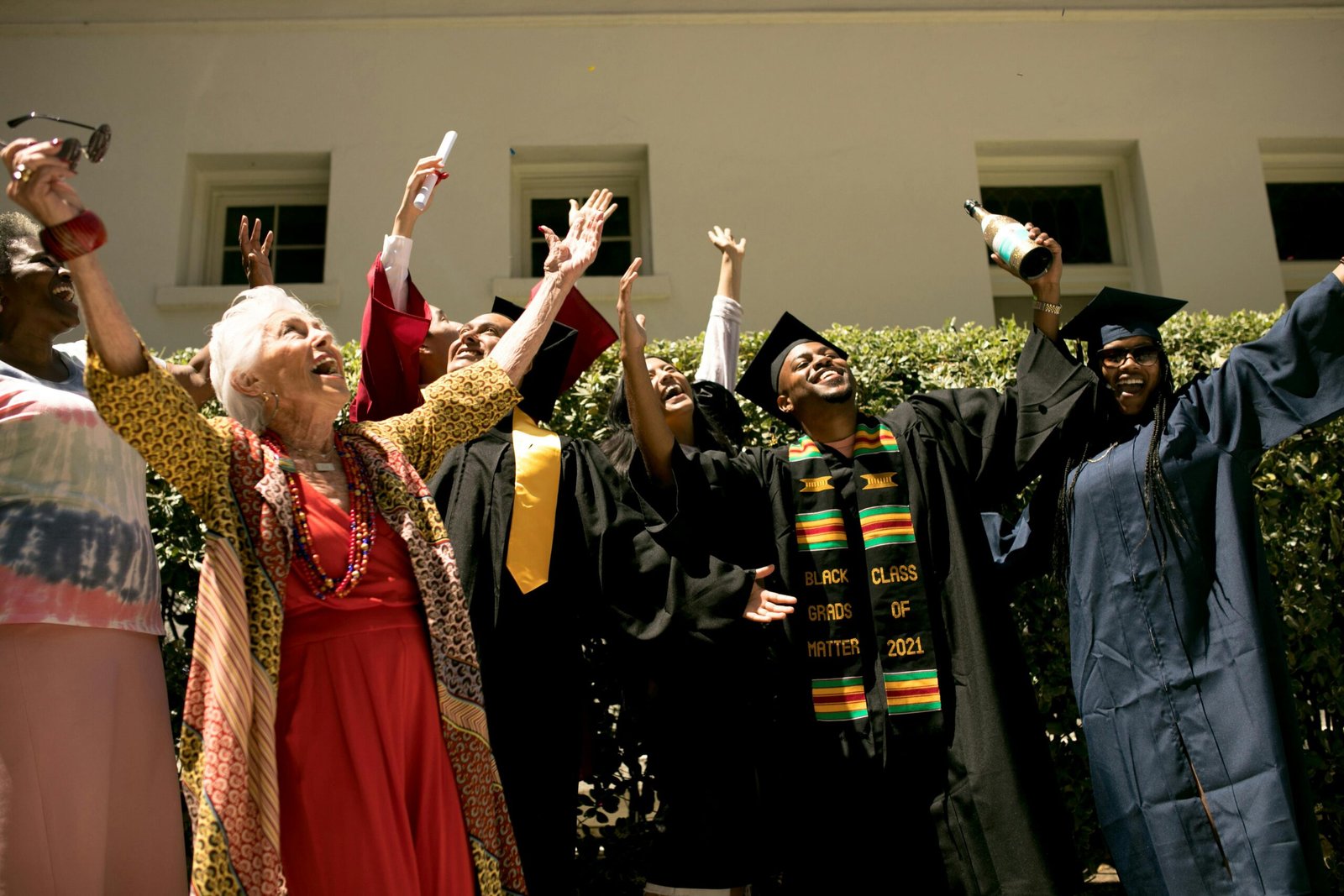 pexels-photo-7713356-7713356 Diverse group celebrating graduation outdoors with family and friends.
